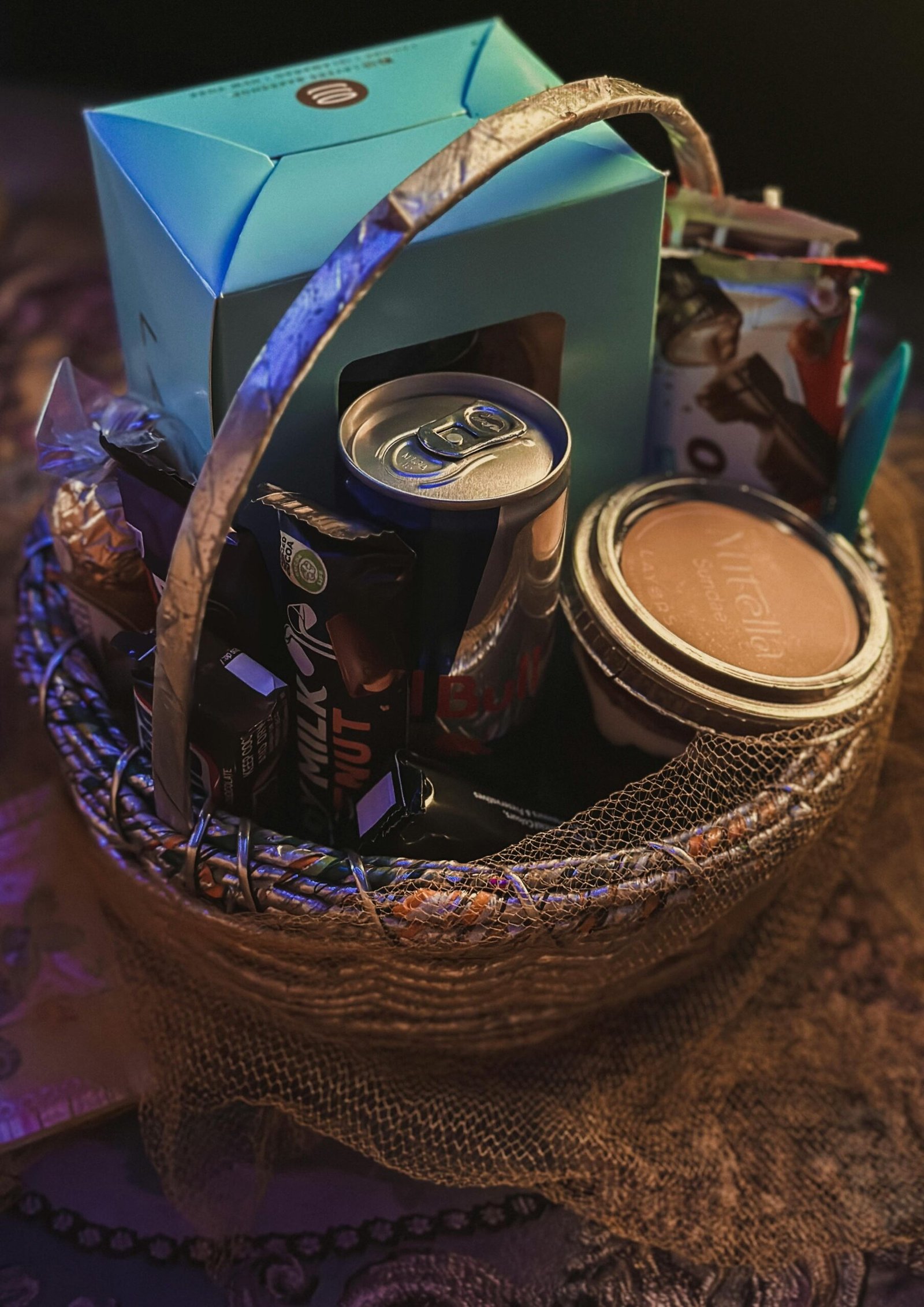 A decorative basket filled with a variety of gourmet snacks and treats, perfect for gifting.
